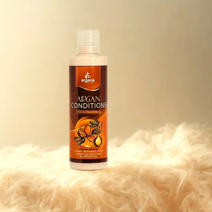 Plaukų kondicionierius su argano aliejumi 200 ml buteliuke ant šviesaus kailio pagrindo.