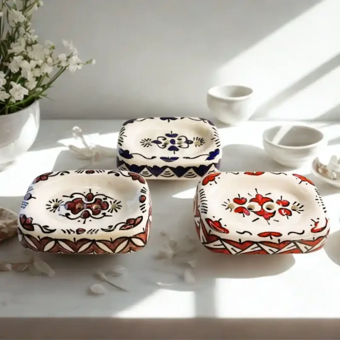 Trys baltos keraminės muilinės dekoruotos spalvingais tradiciniais Maroko raštais.